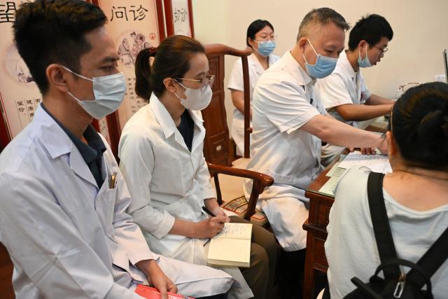 (260918) -- NANNING, Sept. 18, 2026 (Xinhua) -- Thai Thi Hai Yen (2nd L) takes notes while Dr. Tang Yaoping (4th L) treats a patient at the Second Affiliated Hospital of Guangxi University of Chinese Medicine in Nanning, south China's Guangxi Zhuang Autonomous Region, Sept. 17, 2026.
  Vietnamese scholar Thai Thi Hai Yen, 33, enrolled at Guangxi University of Chinese Medicine (GUCM) in September 2025 to pursue her doctoral degree in traditional Chinese internal medicine under the supervision of Professor Chen Guozhong from the university's First Affiliated Hospital. After one year of intensive Chinese language training, she officially commenced her professional traditional Chinese medicine (TCM) studies this September.
  Yen's pursuit in TCM began long before her arrival in China. She obtained her bachelor's and master's degrees in TCM from Vietnam University of Traditional Medicine before she was employed by Da Nang Rehabilitation Hospital. She is now studying diligently to refine her clinical expertise in China.
   "After earning my PhD, I plan to return to Da Nang Rehabilitation Hospital and integrate TCM with multidisciplinary rehabilitation therapies to achieve better treatment outcomes for my patients," Yen said.
   A time-honored hub for TCM education and cultural exchange with ASEAN nations, GUCM capitalizes on its strengths in both TCM and distinctive Zhuang ethnic medicine. The university has been attracting ASEAN students, boosting professional exchanges, and facilitating China-ASEAN cooperation in traditional medicine and people-to-people connectivity. (Xinhua/Sun Huanjie)