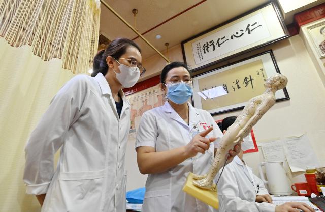 (260918) -- NANNING, Sept. 18, 2026 (Xinhua) -- Dr. Chen Manghua explains acupuncture know-how to Thai Thi Hai Yen (L) at the Second Affiliated Hospital of Guangxi University of Chinese Medicine in Nanning, south China's Guangxi Zhuang Autonomous Region, Sept. 17, 2026.
  Vietnamese scholar Thai Thi Hai Yen, 33, enrolled at Guangxi University of Chinese Medicine (GUCM) in September 2025 to pursue her doctoral degree in traditional Chinese internal medicine under the supervision of Professor Chen Guozhong from the university's First Affiliated Hospital. After one year of intensive Chinese language training, she officially commenced her professional traditional Chinese medicine (TCM) studies this September.
  Yen's pursuit in TCM began long before her arrival in China. She obtained her bachelor's and master's degrees in TCM from Vietnam University of Traditional Medicine before she was employed by Da Nang Rehabilitation Hospital. She is now studying diligently to refine her clinical expertise in China.
   "After earning my PhD, I plan to return to Da Nang Rehabilitation Hospital and integrate TCM with multidisciplinary rehabilitation therapies to achieve better treatment outcomes for my patients," Yen said.
   A time-honored hub for TCM education and cultural exchange with ASEAN nations, GUCM capitalizes on its strengths in both TCM and distinctive Zhuang ethnic medicine. The university has been attracting ASEAN students, boosting professional exchanges, and facilitating China-ASEAN cooperation in traditional medicine and people-to-people connectivity. (Xinhua/Lu Boan)