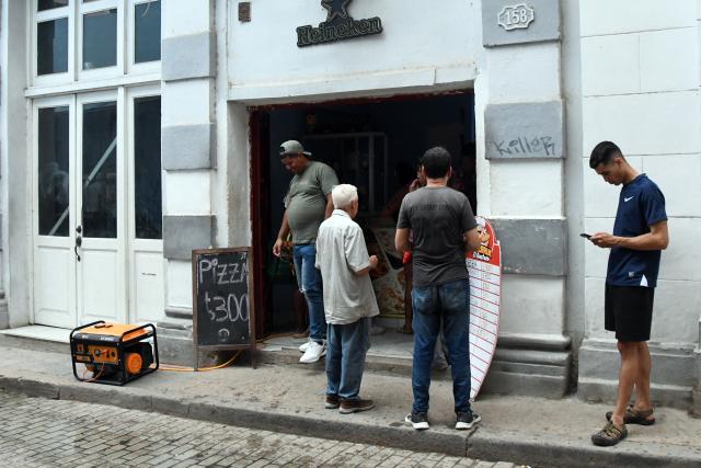 (260919) -- HAVANA, Sept. 19, 2026 (Xinhua) -- People buy food at a deli equipped with an electric generator during a nationwide blackout in Havana, capital of Cuba, Sept. 18, 2026. Cuba suffered another nationwide blackout on Friday after its national power grid completely collapsed, state utility Union Electrica (UNE) said. (Photo by Joaquin Hernandez/Xinhua)