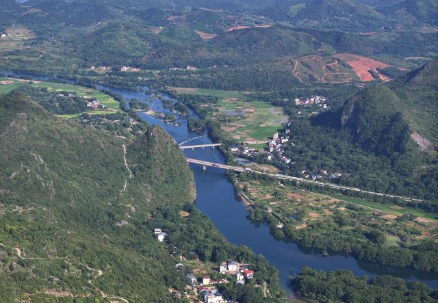 (260919) -- GUILIN, Sept. 19, 2026 (Xinhua) -- An aerial drone photo taken on Aug. 11, 2026 shows a view of the Xiangjiang River in Caiwan Town of Quanzhou County of Guilin City, south China's Guangxi Zhuang Autonomous Region. In the winter of 1934 during the Long March, the Red Army fought its way across the Xiangjiang River in Guangxi and broke through the Kuomintang troops' blockade, but suffered tens of thousands of casualties in the battle.
   In Quanzhou, Guanyang and Xing'an counties, where the Battle of the Xiangjiang River was fought, the spirit of the Long March has been passed down through generations. Today, roads wind through mountains that Red Army soldiers once crossed on foot, connecting once-isolated villages with the outside world. Local people keep striving on the path of rural revitalization. (Xinhua/Huang Xiaobang)