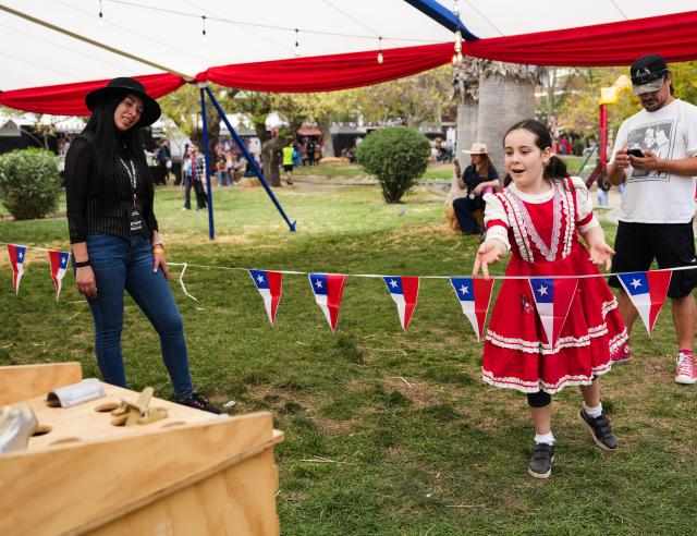 (260919) -- SANTIAGO, Sept. 19, 2026 (Xinhua) -- A girl plays games at a Chilean fonda, a traditional festive gathering and venue for the Independence Day celebrations, in Santiago, Chile, Sept. 18, 2026. Traditional Chilean fondas were set up across Santiago on Friday to celebrate the Independence Day. (Xinhua/Zhou Jiayi)