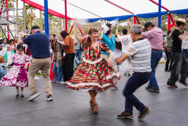 (260919) -- SANTIAGO, Sept. 19, 2026 (Xinhua) -- People take part in a cueca dance at a Chilean fonda, a traditional festive gathering and venue for the Independence Day celebrations, in Santiago, Chile, Sept. 18, 2026. Traditional Chilean fondas were set up across Santiago on Friday to celebrate the Independence Day. (Xinhua/Zhou Jiayi)