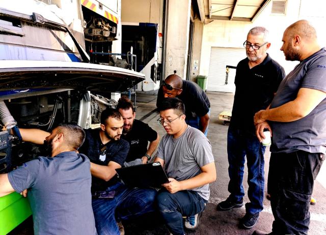 (260919) -- RAMLA, Sept. 19, 2026 (Xinhua) -- This photo taken on June 4, 2026 shows a Chinese engineer of Zhongtong Bus (4th R) explaining maintenance techniques to local technicians in Ramla, Israel. Zhongtong Bus has provided training for overseas drivers and maintenance personnel, helping local operators build skills in vehicle operation and maintenance. (Zhongtong Bus/Handout via Xinhua)