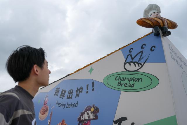 (260919) -- SUZHOU, Sept. 19, 2026 (Xinhua) -- Hou Jinchen looks at an installation related to bakery at Suzhou Wuzhong Technician College in Suzhou, east China's Jiangsu Province, Aug. 30, 2026. Born in 2005, Hou Jinchen studies culinary arts at Suzhou Wuzhong Technician College. He began learning to bake at the age of 12, and his passion for it has grown ever since.
   From shaping dough to baking and decorating bread, Hou follows a rigorous training routine. He practices the same techniques over and over to build muscle memory, carefully recording changes in temperature and ingredient quantities during each session and constantly refining the details.
   Outside training, he also visits local bakeries to learn from working bakers. He believes they have a better understanding of consumer preferences, which gives him insights that training focused solely on competitions may not always provide.
   His efforts have earned him both gold and bronze medals in national vocational skills competitions, and he was later selected for the national team. The 21-year-old is now preparing for the upcoming WorldSkills Competition in Shanghai.
   Among all the competition tasks, Hou devotes particular attention to artistic bread design. From sketching ideas to making molds and baking the final pieces, the process requires repeated adjustments. He sometimes uses 3D-printed molds and plans to incorporate more Chinese elements into his competition pieces in Shanghai.
   For Hou, baking is not just a technical skill, but also a pursuit of craftsmanship. He hopes to showcase the skills and dedication of young Chinese bakers on the international stage.
   "I can't imagine leaving the baking industry," Hou said. "In the future, I hope to become a coach and pass on what I have learned to younger bakers." (Xinhua/Li Bo)