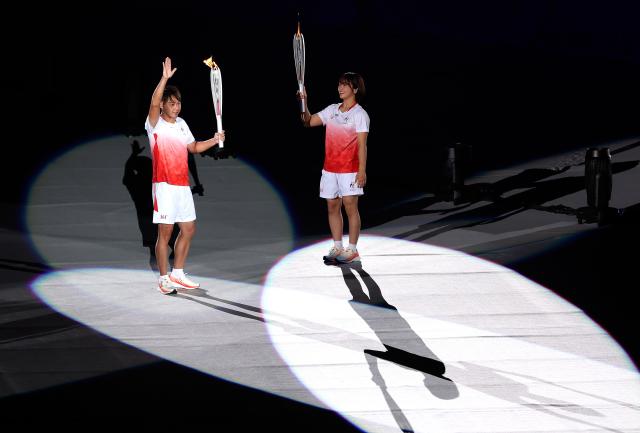 (260919) -- NAGOYA, Sept. 19, 2026 (Xinhua) -- Torch bearers Kitajima Kosuke (L) and Fujinami Akari hand over the flame during the opening ceremony of the 20th Asian Games Aichi-Nagoya 2026 in Nagoya, Japan, Sept. 19, 2026. (Xinhua/Wang Fei)