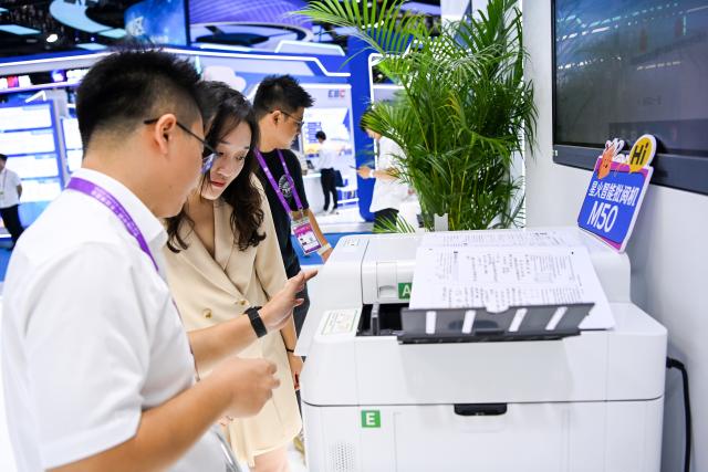 (260919) -- NANNING, Sept. 19, 2026 (Xinhua) -- A visitor learns about an AI-powered intelligent marking machine during the 23rd China-ASEAN Expo in Nanning, south China's Guangxi Zhuang Autonomous Region, Sept. 18, 2026. AI-related products have taken center stage at the ongoing 23rd China-ASEAN Expo, which attracts more than 3,400 companies from China, the Association of Southeast Asian Nations (ASEAN) and beyond. (Xinhua/Cao Yiming)