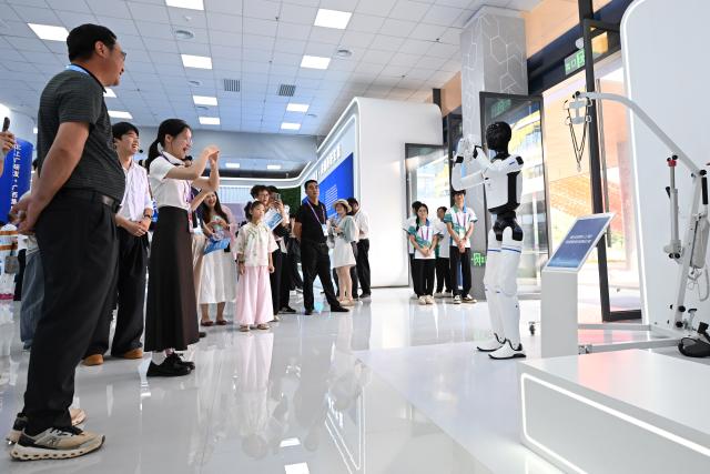 (260919) -- NANNING, Sept. 19, 2026 (Xinhua) -- A visitor interacts with a humanoid robot during the 23rd China-ASEAN Expo in Nanning, south China's Guangxi Zhuang Autonomous Region, Sept. 19, 2026. AI-related products have taken center stage at the ongoing 23rd China-ASEAN Expo, which attracts more than 3,400 companies from China, the Association of Southeast Asian Nations (ASEAN) and beyond. (Xinhua/Huang Xiaobang)