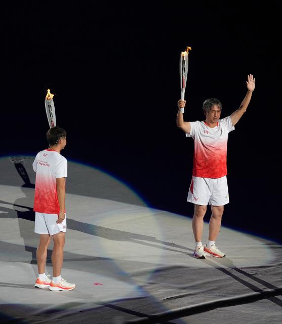 (260919) -- NAGOYA, Sept. 19, 2026 (Xinhua) -- Torch bearers Kitajima Kosuke (L) and Ito Koji hand over the torch during the opening ceremony of the 20th Asian Games Aichi-Nagoya 2026 in Nagoya, Japan, Sept. 19, 2026. (Xinhua/Zhou Mi)