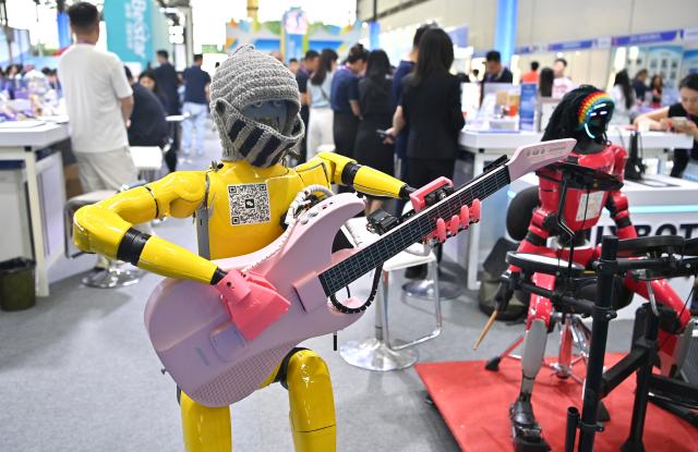 (260919) -- NANNING, Sept. 19, 2026 (Xinhua) -- A humanoid robot plays the guitar at the 23rd China-ASEAN Expo in Nanning, south China's Guangxi Zhuang Autonomous Region, Sept. 19, 2026. Multiple intelligent robots were showcased and demonstrated a variety of skills at the China-ASEAN Expo. (Xinhua/Zhou Hua)