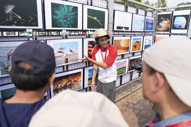 (260919) -- PINGYAO, Sept. 19, 2026 (Xinhua) -- A photographer introduces works to visitors at the 26th Pingyao International Photography Festival (PIP) in Pingyao ancient town in Jinzhong, north China's Shanxi Province, Sept. 19, 2025. The 26th PIP kicked off here on Saturday, featuring works by more than 2,600 photographers from over 30 countries and regions. The event will run until Sept. 23. (Xinhua/Yang Chenguang)