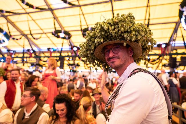 (260919) -- MUNICH, Sept. 19, 2026 (Xinhua) -- A man wearing a hat decorated with hops is pictured at the Oktoberfest in Munich, Germany, Sept. 19, 2026. The 191st Oktoberfest, one of the largest folk festivals in Germany, opened on Saturday in Munich, with mayor Dominik Krause tapping the first barrel of beer as a tradition. This year's festival will last until Oct. 4. (Xinhua/Zhang Haofu)