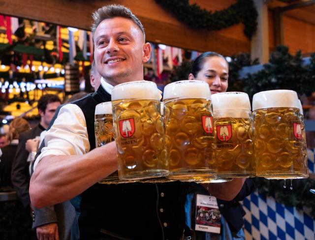 (260919) -- MUNICH, Sept. 19, 2026 (Xinhua) -- A staff member carries cups of beer at the Oktoberfest in Munich, Germany, Sept. 19, 2026. The 191st Oktoberfest, one of the largest folk festivals in Germany, opened on Saturday in Munich, with mayor Dominik Krause tapping the first barrel of beer as a tradition. This year's festival will last until Oct. 4. (Xinhua/Zhang Haofu)