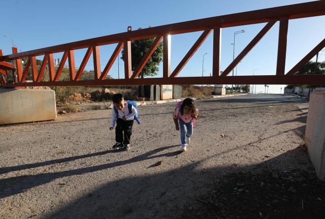 (260919) -- NABLUS, Sept. 19, 2026 (Xinhua) -- Palestinian children pass through a closed Israeli checkpoint gate in the village of Qusra, south of Nablus, in the West Bank, on Sept. 16, 2026. TO GO WITH "Feature: A journey to school through fear and barriers" (Photo by Nidal Eshtayeh/Xinhua)