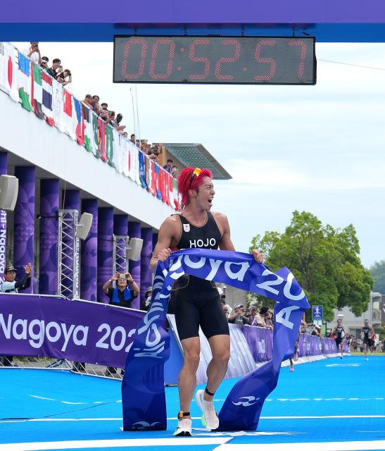 (260920) -- NAGOYA, Sept. 20, 2026 (Xinhua) -- Hojo Takumi of Japan celebrates after crossing the finish line during the men's individual triathlon at the 20th Asian Games Aichi-Nagoya 2026 in Gamagori City of Aichi prefecture, Japan, Sept. 20, 2026. (Xinhua/Cen Yunpeng)