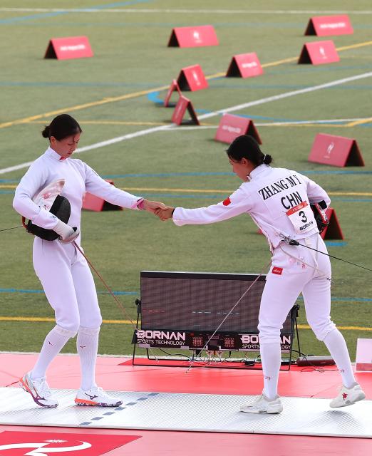 (260920) -- NAGOYA, Sept. 20, 2026 (Xinhua) -- Zhang Mingyu (R) of China shakes hands with Uchida Misaki of Japan during the women's individual final, fencing direct elimination round of modern pentathlon at the 20th Asian Games Aichi-Nagoya 2026 in Anjo city of Aichi Prefecture, Japan, Sept. 20, 2026. (Xinhua/Yao Qilin)