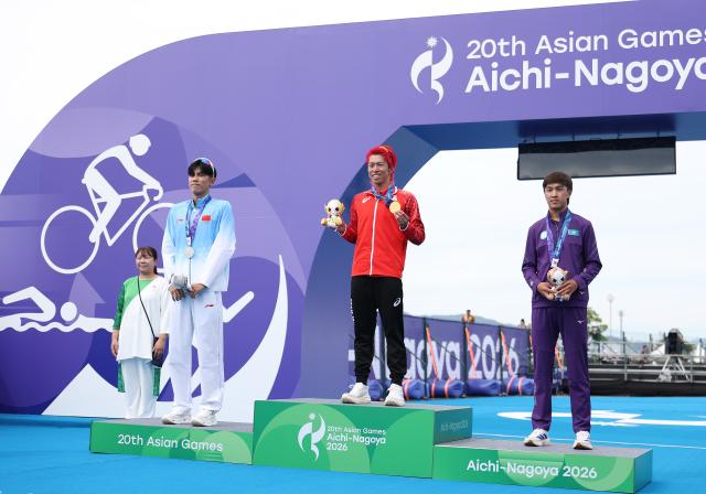 (260920) -- NAGOYA, Sept. 20, 2026 (Xinhua) -- Gold medalist Hojo Takumi (C) of Japan, silver medalist Zhang Xirui (L) of China and bronze medalist Arlan Zhanabay of Kazakhstan pose during the victory ceremony for the men's individual final of triathlon at the 20th Asian Games Aichi-Nagoya 2026 in Gamagori City of Aichi Prefecture, Japan, Sept. 20, 2026. (Xinhua/Deng Hua)