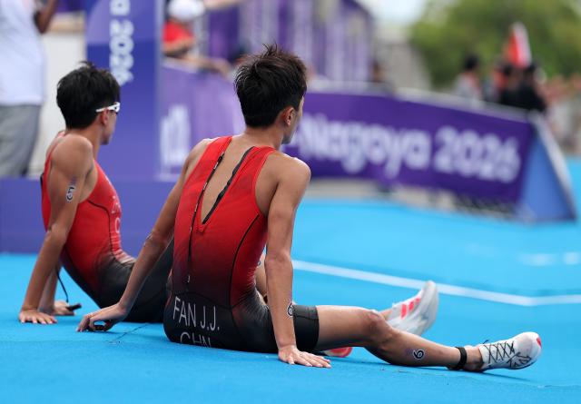 (260920) -- NAGOYA, Sept. 20, 2026 (Xinhua) -- Zhang Xirui and Fan Junjie (R) of China react after the men's individual final of triathlon at the 20th Asian Games Aichi-Nagoya 2026 in Gamagori City of Aichi Prefecture, Japan, Sept. 20, 2026. (Xinhua/Deng Hua)