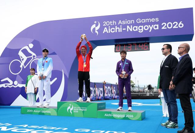 (260920) -- NAGOYA, Sept. 20, 2026 (Xinhua) -- Gold medalist Hojo Takumi (C) of Japan, silver medalist Zhang Xirui (L) of China and bronze medalist Arlan Zhanabay of Kazakhstan pose during the victory ceremony for the men's individual final of triathlon at the 20th Asian Games Aichi-Nagoya 2026 in Gamagori City of Aichi Prefecture, Japan, Sept. 20, 2026. (Xinhua/Deng Hua)