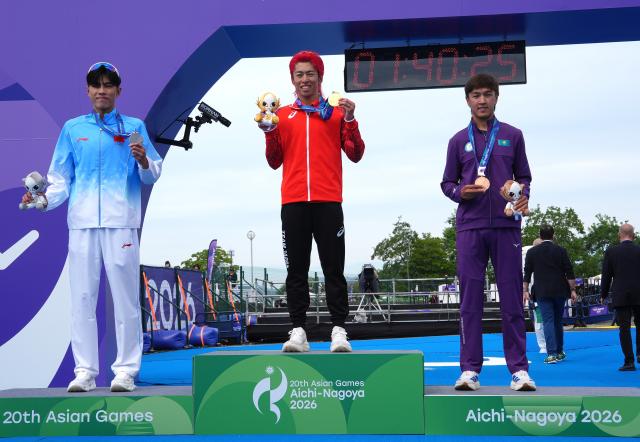 (260920) -- NAGOYA, Sept. 20, 2026 (Xinhua) -- Gold medalist Hojo Takumi (C) of Japan, silver medalist Zhang Xirui (L) of China and bronze medalist Arlan Zhanabay of Kazakhstan pose during the victory ceremony for the men's individual final of triathlon at the 20th Asian Games Aichi-Nagoya 2026 in Gamagori City of Aichi Prefecture, Japan, Sept. 20, 2026. (Xinhua/Cen Yunpeng)