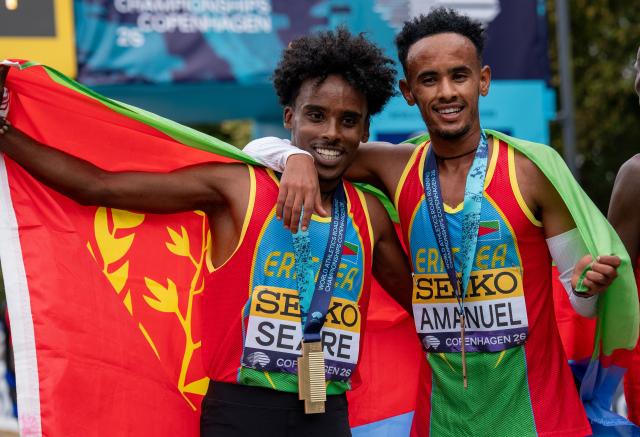 (260920) -- COPENHAGEN, Sept. 20, 2026 (Xinhua) -- Gold medalist Dawit Seare (L) and bronze medalist Saymon Amanuel of Eritrea celebrate with their national flag after the men's 5km race at the World Athletics Road Running Championships in Copenhagen, Denmark, Sept. 19, 2026. (Photo by Anders Kongshaug/Xinhua)