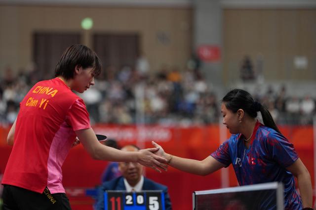 (260920) -- NAGOYA, Sept. 20, 2026 (Xinhua) -- Chen Yi (L) of team China greets with Evana Thapa of team Nepal after the women's team Group A table tennis match between China and Nepal at the 20th Asian Games Aichi-Nagoya 2026 in Toyota, Japan, Sept. 20, 2026. (Xinhua/Cheong Kam Ka)