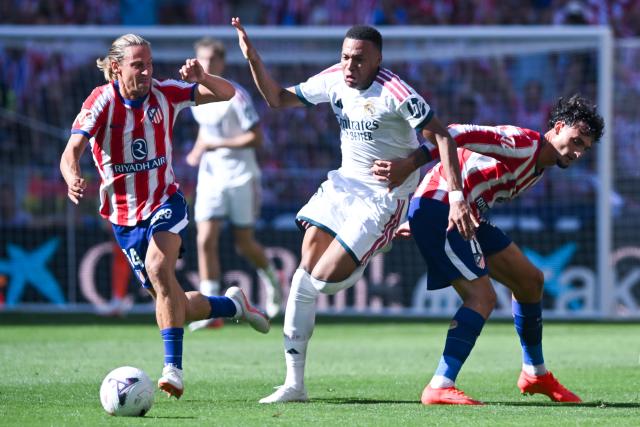 (260921) -- MADRID, Sept. 21, 2026 (Xinhua) -- Atletico de Madrid's' Marc Pubill (R) vies with Real Madrid's Kylian Mbappe (C) during a La Liga football match between Atletico de Madrid and Real Madrid at Riyadh Air Metropolitano stadium in Madrid, Spain, on Sept. 20, 2026. (Photo by Gustavo Valiente/Xinhua)