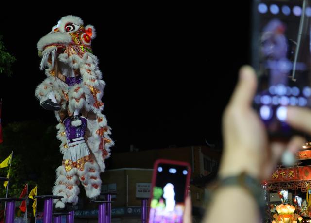 (260921) -- SYDNEY, Sept. 21, 2026 (Xinhua) -- People take photos of a lion dance performance during the Cabramatta Moon Festival in Cabramatta, 26 km west of central Sydney, Australia, Sept. 20, 2026. (Xinhua/Gong Bing)