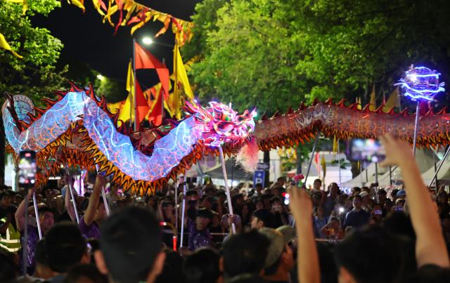(260921) -- SYDNEY, Sept. 21, 2026 (Xinhua) -- People watch a dragon dance performance during the Cabramatta Moon Festival in Cabramatta, 26 km west of central Sydney, Australia, Sept. 20, 2026. (Xinhua/Gong Bing)
