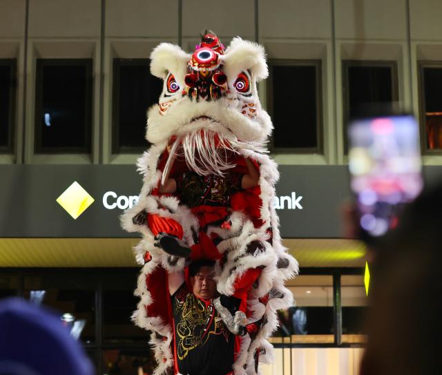 (260921) -- SYDNEY, Sept. 21, 2026 (Xinhua) -- People take photos of a lion dance performance during the Cabramatta Moon Festival in Cabramatta, 26 km west of central Sydney, Australia, Sept. 20, 2026. (Xinhua/Gong Bing)