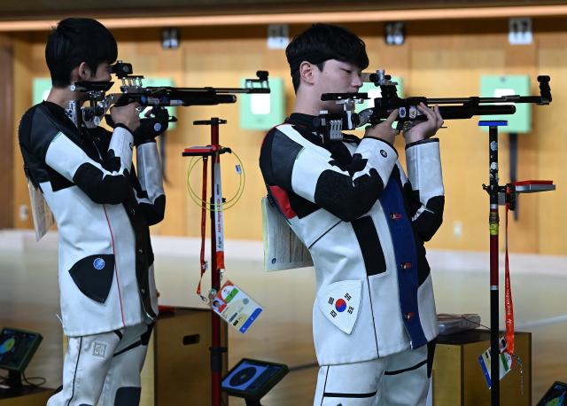 (260921) -- NAGOYA, Sept. 21, 2026 (Xinhua) -- Shin Minki (R) of team South Korea reacts during the 10m air rifle men team final of shooting at the 20th Asian Games Aichi-Nagoya 2026 in Toyota of Aichi Prefecture, Japan, Sept. 21, 2026. (Xinhua/Liu Lei)