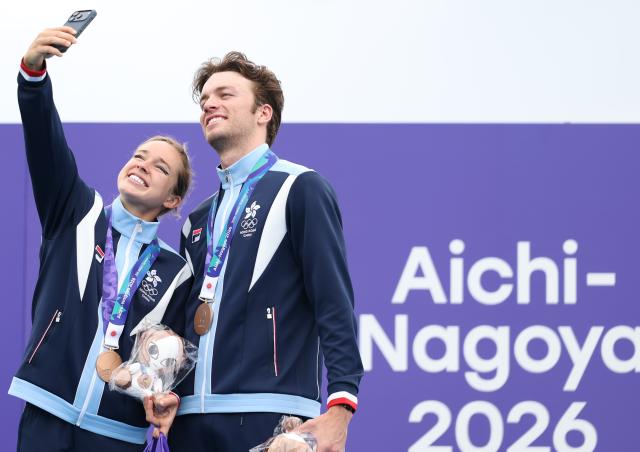 (260921) -- NAGOYA, Sept. 21, 2026 (Xinhua) -- Robin Bent Edvin Thomas Elg (R) and Bailee Briana Brown of team Hong Kong, China take a selfie to celebrate during the victory ceremony for the mixed relay event of triathlon at the 20th Asian Games Aichi-Nagoya 2026 in Gamagori City of Aichi Prefecture, Japan, Sept. 21, 2026. (Xinhua/Deng Hua)