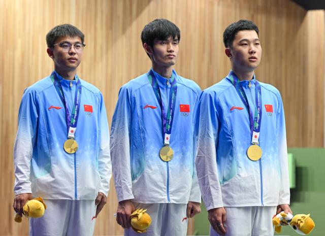 (260921) -- NAGOYA, Sept. 21, 2026 (Xinhua) -- Gold medalists Ma Sihan, Sheng Lihao and Zhang Changhong (from R to L) of team China react on the podium during the victory ceremony for the 10m air rifle men team of shooting at the 20th Asian Games Aichi-Nagoya 2026 in Toyota of Aichi Prefecture, Japan, Sept. 21, 2026. (Xinhua/Liu Lei)
