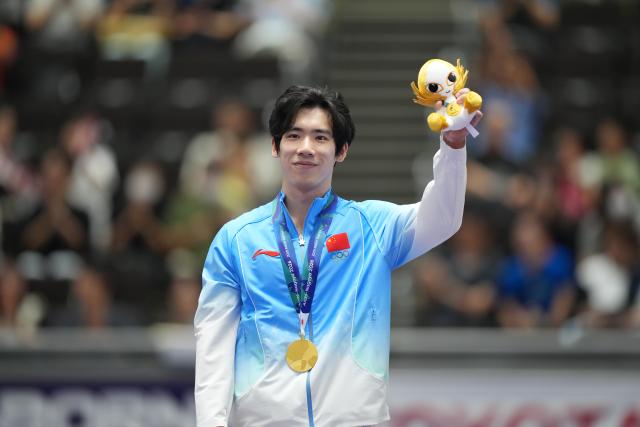 (260921) -- NAGOYA, Sept. 21, 2026 (Xinhua) -- Gold medalist Zhang Boheng of China reacts during the awarding ceremony for the men's all-around of Artistic Gymnastics at the 20th Asian Games Aichi-Nagoya 2026 in Nagoya, Japan, Sept. 21, 2026. (Xinhua/Lui Siu Wai)