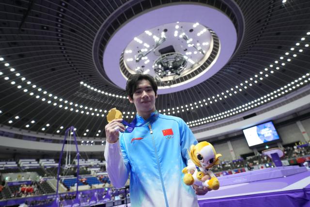 (260921) -- NAGOYA, Sept. 21, 2026 (Xinhua) -- Gold medalist Zhang Boheng of China poses after the awarding ceremony for the men's all-around of Artistic Gymnastics at the 20th Asian Games Aichi-Nagoya 2026 in Nagoya, Japan, Sept. 21, 2026. (Xinhua/Lui Siu Wai)