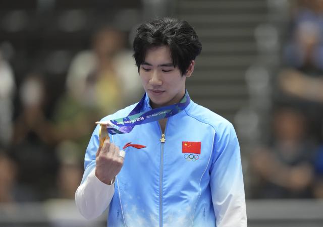 (260921) -- NAGOYA, Sept. 21, 2026 (Xinhua) -- Gold medalist Zhang Boheng of China reacts during the awarding ceremony for the men's all-around of Artistic Gymnastics at the 20th Asian Games Aichi-Nagoya 2026 in Nagoya, Japan, Sept. 21, 2026. (Xinhua/Lui Siu Wai)