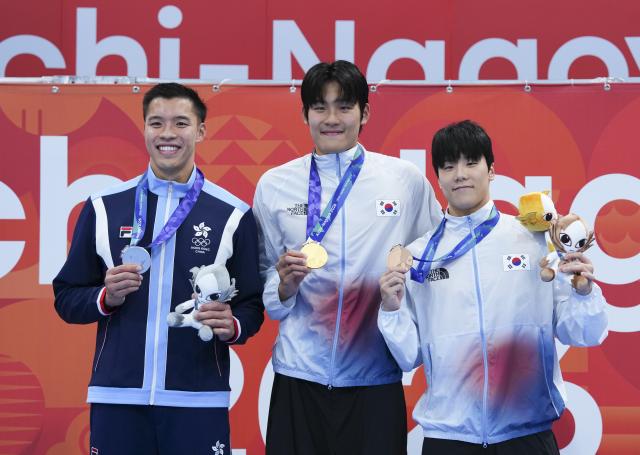 (260921) -- TOKYO, Sept. 21, 2026 (Xinhua) -- Gold medalist Kim Youngbeom (C) of South Korea, Silver medalist Ho Ian Yentou of China's Hong Kong and Bronze medalist Ji Yuchan of South Korea pose on the awarding ceremony after the men's 50m freestyle final at the 20th Asian Games Aichi-Nagoya 2026 in Tokyo, Japan, Sept. 21, 2026. (Xinhua/Chen Zeguo)
