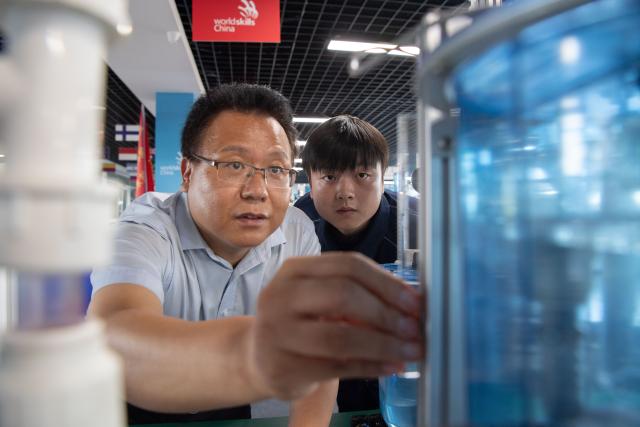 (260921) -- ZHENGZHOU, Sept. 21, 2026 (Xinhua) -- Lu Yi (R) trains with his coach at Henan Chemical Technician College in Kaifeng City, central China's Henan Province, Sept. 1, 2026. At a training base of Henan Chemical Technician College, 23-year-old Lu Yi is preparing for the water technology event of the upcoming 48th WorldSkills Competition.
  Lu enrolled at Henan Chemical Technician College in 2019 and began training for the water technology event three years later. The water technology event focuses on evaluating competitors' abilities in wastewater treatment process operations, water quality analysis, mechanical equipment maintenance, and electrical automation. In 2025, Lu won the gold medal in the water technology event at China's third Vocational Skills Competition.
  During his daily training for the upcoming 48th WorldSkills Competition, Lu spends almost all his time in the laboratory, working with his coach to improve speed and adjust every detail of his movements. (Photo by Kong Weijia/Xinhua)