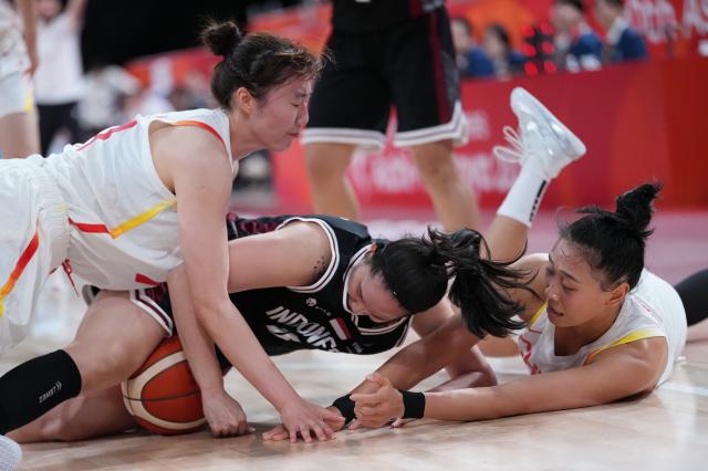 (260921) -- NAGOYA, Sept. 21, 2026 (Xinhua) -- Tang Ziting (R) and Luo Xinyu (L) of China block Priscilla Karen of Indonesia during the women's group A basketball match between China and Indonesia at the 20th Asian Games Aichi-Nagoya 2026 in Nagoya, Japan, Sept. 21, 2026. (Xinhua/Luo Yuan)