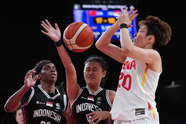 (260921) -- NAGOYA, Sept. 21, 2026 (Xinhua) -- Sun Yu (R) of China is blocked by players of Indonesia during the women's group A basketball match between China and Indonesia at the 20th Asian Games Aichi-Nagoya 2026 in Nagoya, Japan, Sept. 21, 2026. (Xinhua/Luo Yuan)