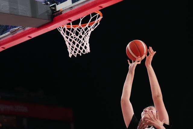 (260921) -- NAGOYA, Sept. 21, 2026 (Xinhua) -- Zhang Ziyu (top) of China goes for a basket during the women's group A basketball match between China and Indonesia at the 20th Asian Games Aichi-Nagoya 2026 in Nagoya, Japan, Sept. 21, 2026. (Xinhua/Luo Yuan)