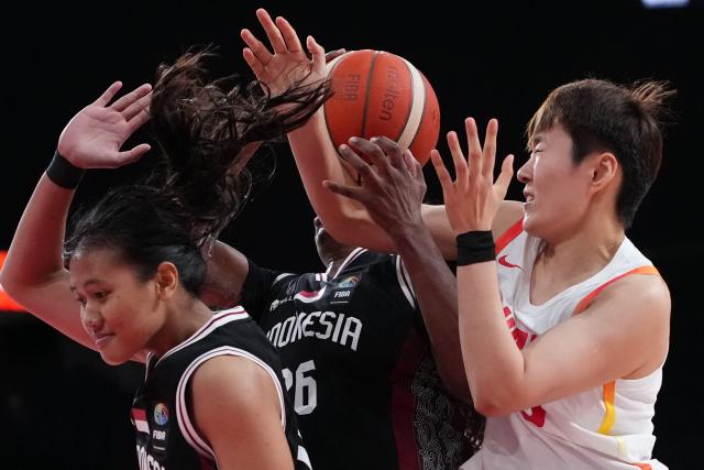 (260921) -- NAGOYA, Sept. 21, 2026 (Xinhua) -- Sun Yu (R) of China is blocked by players of Indonesia during the women's group A basketball match between China and Indonesia at the 20th Asian Games Aichi-Nagoya 2026 in Nagoya, Japan, Sept. 21, 2026. (Xinhua/Luo Yuan)
