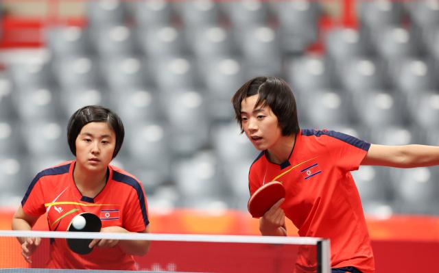 (260921) -- TOYOTA, Sept. 21, 2026 (Xinhua) -- Kim Kum Yong (L)/Cha Su Yong of the Democratic People's Republic of Korea (DPRK) compete during the women's doubles group stage first-round match against Tushi Samanta/Mahi Nowrin of Bangladesh at the 20th Asian Games Aichi-Nagoya 2026 in Toyota, Japan, Sept. 21, 2026. (Xinhua/Yao Qilin)