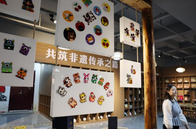 (260921) -- GUYUAN, Sept. 21, 2026 (Xinhua) -- Duoxiu embroidery works are displayed at a study tour base in Yuanzhou District, Guyuan City of northwest China's Ningxia Hui Autonomous Region, Sept. 21, 2026. Yuanzhou District in Guyuan City has developed an integrated model combining intangible cultural heritage, original design and e-commerce, encouraging local businesses to develop original Duoxiu embroidery patterns and expand handicraft markets. The district has established 12 community handicraft workshops, creating jobs for more than 3,600 people and turning traditional skills into economic opportunities. (Xinhua/Liu Yun)