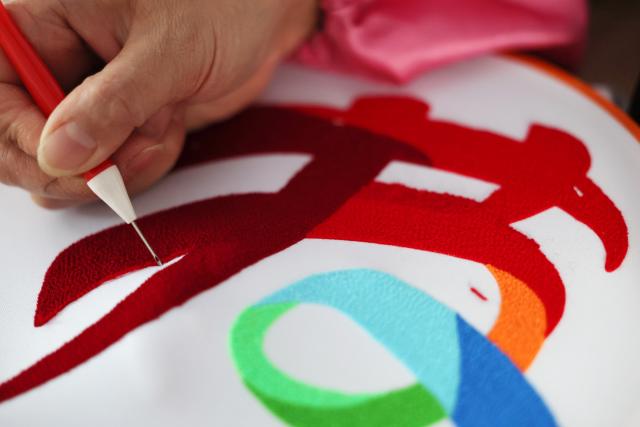 (260921) -- GUYUAN, Sept. 21, 2026 (Xinhua) -- A worker makes Duoxiu embroidery works at a workshop in Yuanzhou District, Guyuan City of northwest China's Ningxia Hui Autonomous Region, Sept. 21, 2026. Yuanzhou District in Guyuan City has developed an integrated model combining intangible cultural heritage, original design and e-commerce, encouraging local businesses to develop original Duoxiu embroidery patterns and expand handicraft markets. The district has established 12 community handicraft workshops, creating jobs for more than 3,600 people and turning traditional skills into economic opportunities. (Xinhua/Liu Yun)