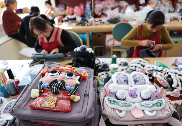 (260921) -- GUYUAN, Sept. 21, 2026 (Xinhua) -- Workers make handicrafts at a workshop in Yuanzhou District, Guyuan City of northwest China's Ningxia Hui Autonomous Region, Sept. 21, 2026. Yuanzhou District in Guyuan City has developed an integrated model combining intangible cultural heritage, original design and e-commerce, encouraging local businesses to develop original Duoxiu embroidery patterns and expand handicraft markets. The district has established 12 community handicraft workshops, creating jobs for more than 3,600 people and turning traditional skills into economic opportunities. (Xinhua/Liu Yun)