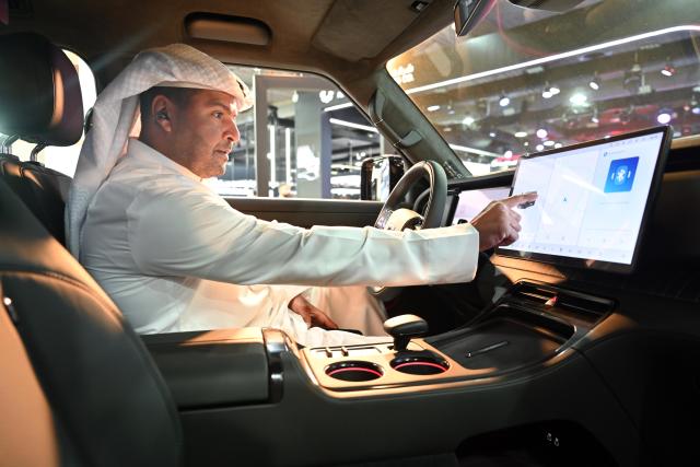 (260921) -- HAWALLI GOVERNORATE, Sept. 21, 2026 (Xinhua) -- A man sits inside a car at an auto show in Hawalli Governorate, Kuwait, Sept. 21, 2026. An auto show opened at the Kuwait International Fairground in Hawalli Governorate on Monday. (Photo by Asad/Xinhua)