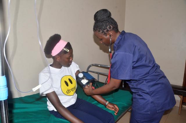 (260921) -- KAMPALA, Sept. 21, 2026 (Xinhua) -- Flavia Nakaayi (R), a Ugandan nurse and one of the competitors of the 48th WorldSkills Competition in Shanghai, checks a patient in Kampala, Uganda, Sept. 16, 2026. TO GO WITH "Feature: From Kampala to Shanghai, young Ugandan nurse takes first step onto WorldSkills stage" (Photo by Nicholas Kajoba/Xinhua)