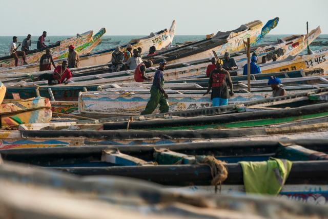 (260922) -- BEIJING, Sept. 22, 2026 (Xinhua) -- People enjoy leisure time amid traditional wooden pirogues at the Nouakchott Fishing Port in Nouakchott, Mauritania, Sept. 20, 2026. The Nouakchott Fishing Port, located on the Atlantic coast, is an important fishing hub in Mauritania. The port is known for its rows of traditional wooden pirogues and is a popular gathering place for local residents. (Xinhua/Xie Jianfei)
