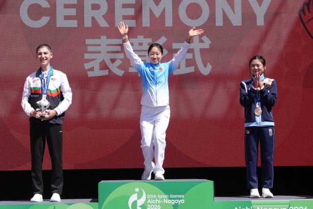 (260922) -- NAGOYA, Sept. 22, 2026 (Xinhua) -- Gold medalist Guo Li (C) of China, silver medalist Fariba Hashimi (L) of Afghanistan and bronze medalist Leung Wing Yee of Hong Kong, China attend the victory ceremony for the women's road race event of cycling road at the 20th Asian Games Aichi-Nagoya 2026 in Shinshiro of Aichi Prefecture, Japan, Sept. 22, 2026. (Xinhua/Cen Yunpeng)