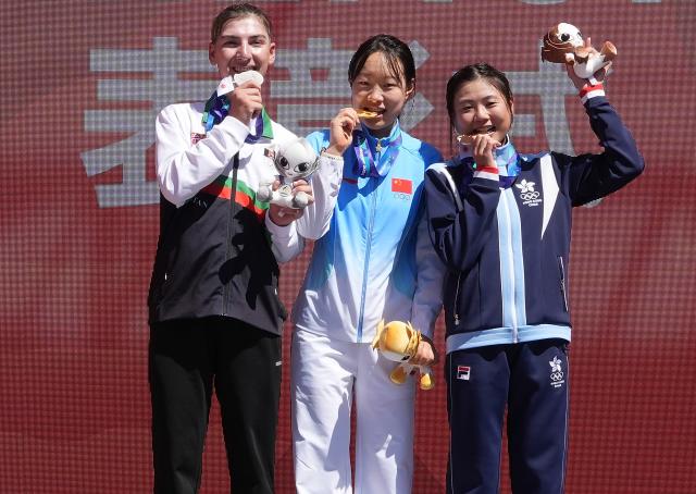 (260922) -- NAGOYA, Sept. 22, 2026 (Xinhua) -- Gold medalist Guo Li (C) of China, silver medalist Fariba Hashimi (L) of Afghanistan and bronze medalist Leung Wing Yee of Hong Kong, China pose during the victory ceremony for the women's road race event of cycling road at the 20th Asian Games Aichi-Nagoya 2026 in Shinshiro of Aichi Prefecture, Japan, Sept. 22, 2026. (Xinhua/Cen Yunpeng)